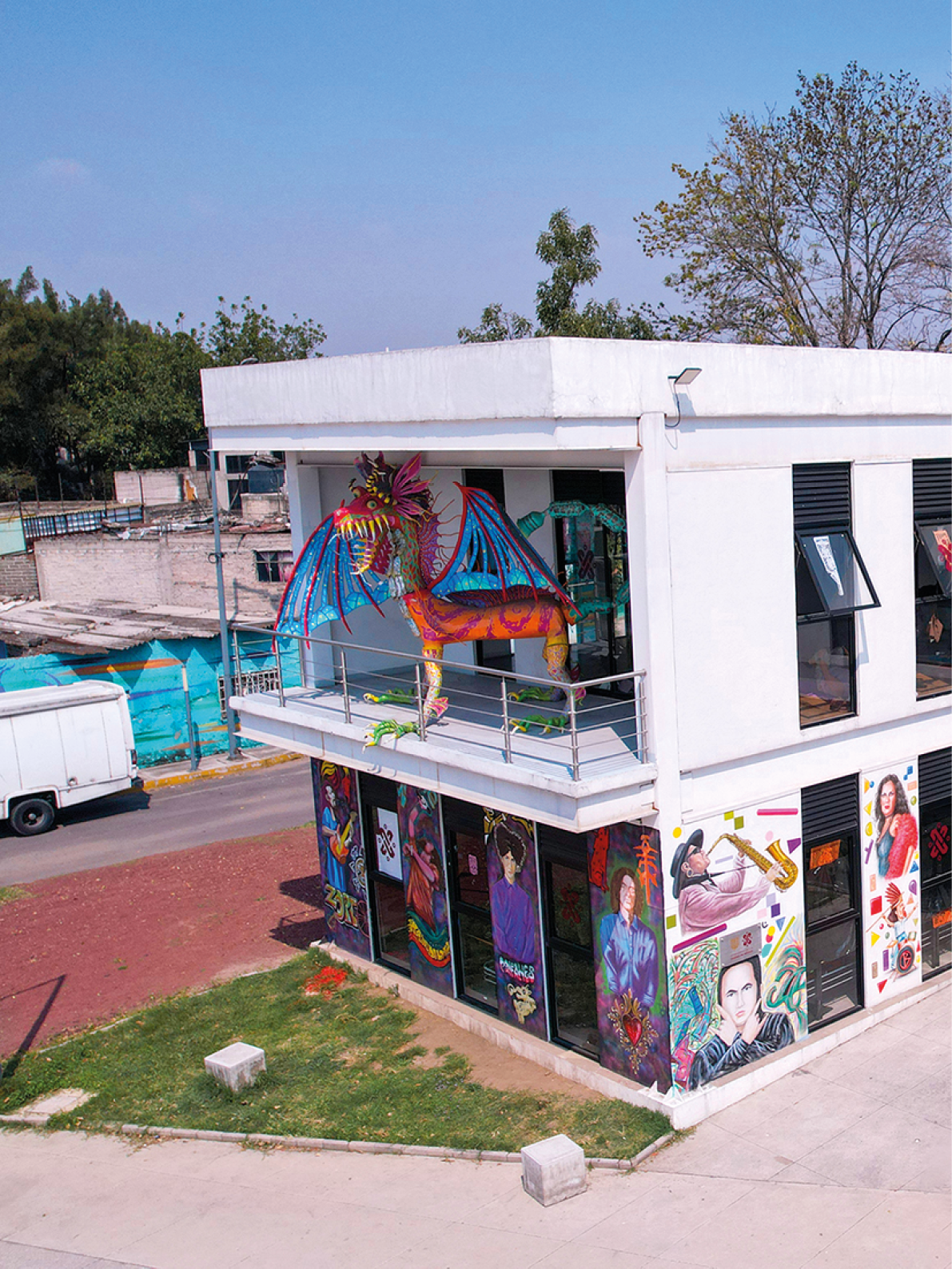 A white building with a red sign that says “Plaza". The building has a lot of graffiti on it and a mural of a woman painted on the side. Contenido generado con IA