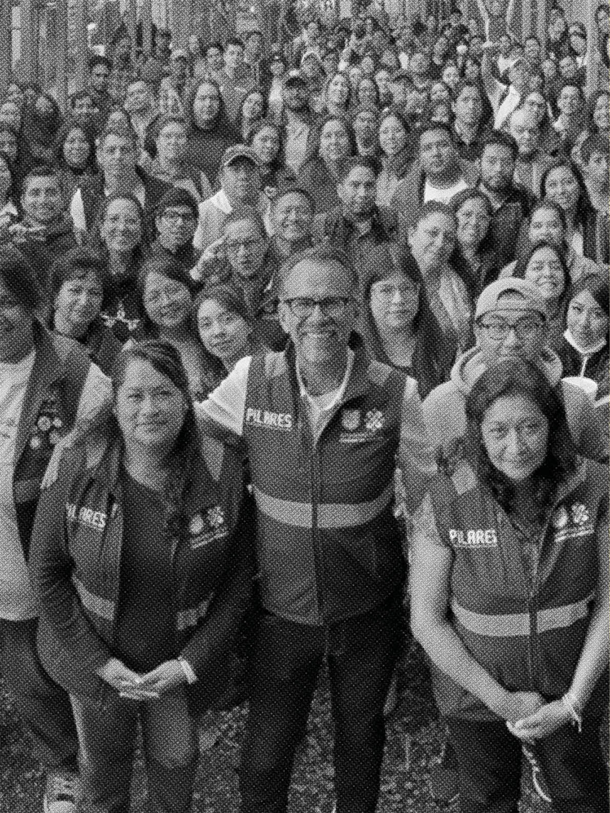 A group of people wearing vests pose for a photo. Contenido generado con IA