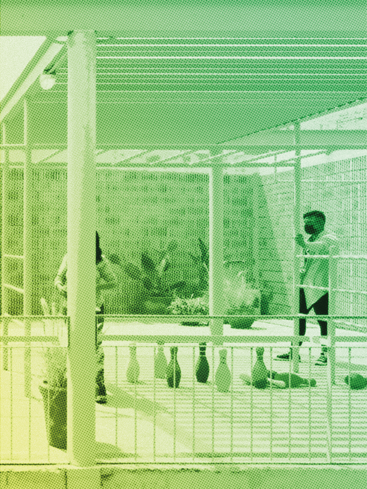 A man is standing in front of a brick wall with a table and chairs. There are two people in the scene, one of them is standing near the table. Contenido generado con IA